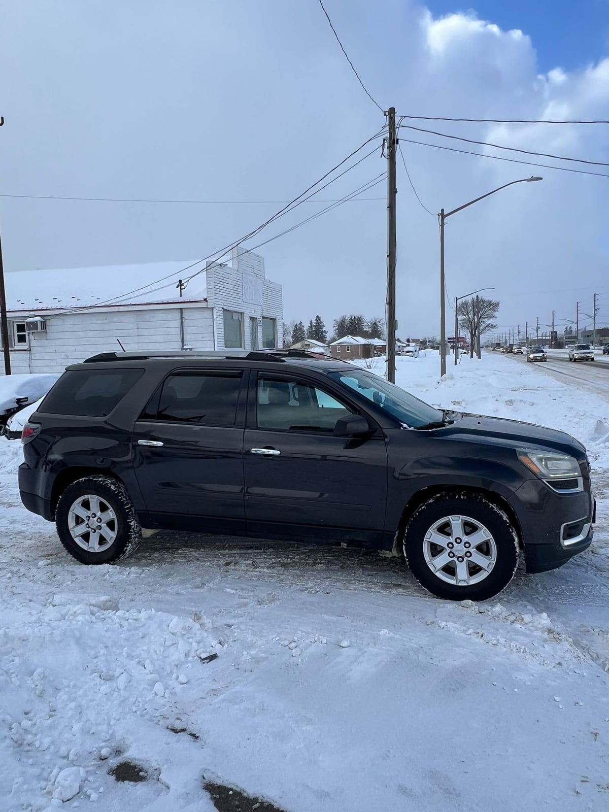 2015 GMC ACADIA SLE AWD 4DR GRAY driver side exterior view with silver alloy wheels parked in snowy winter setting.