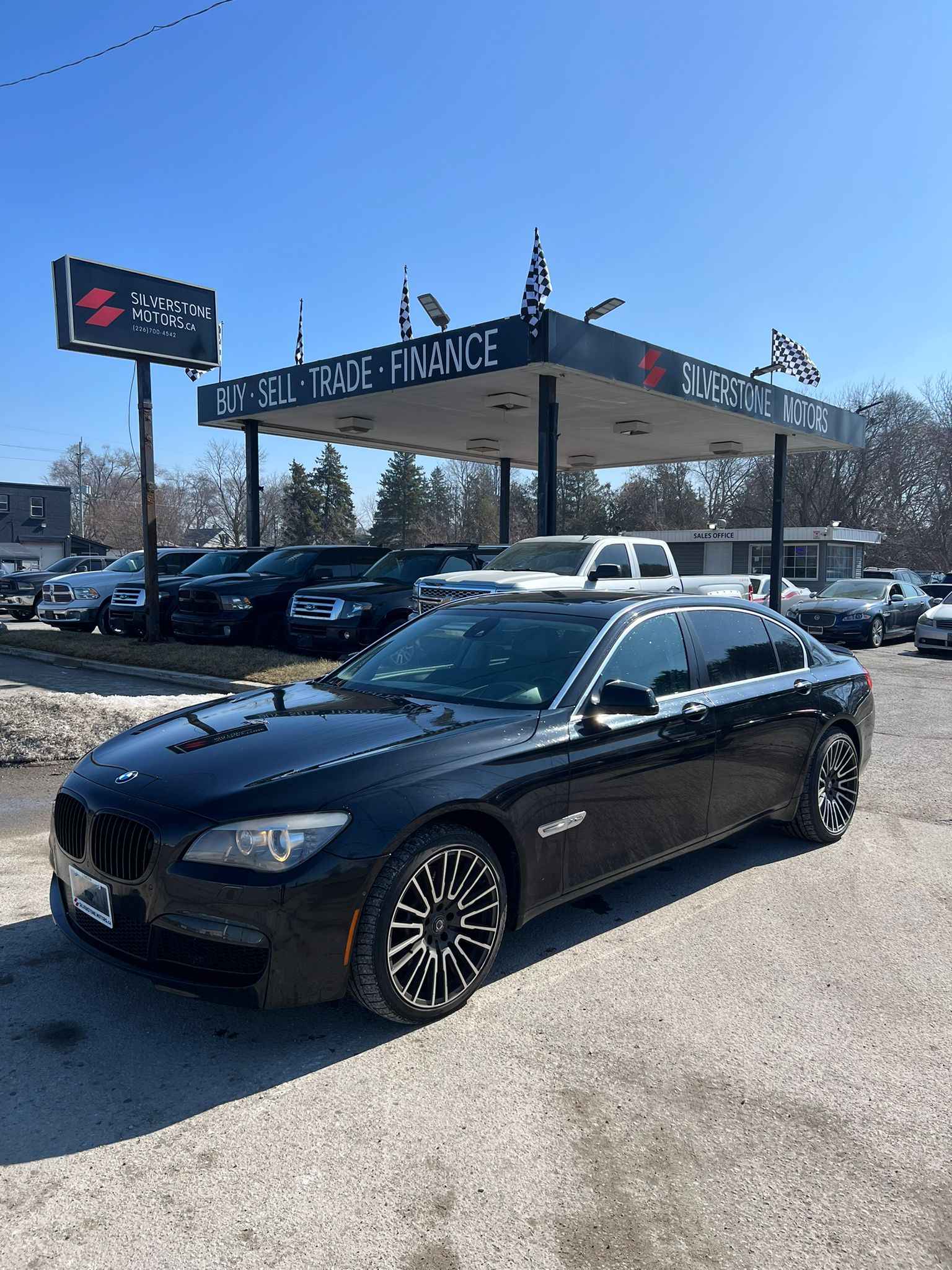 2012 BMW 750LI XDRIVE AWD 4DR BLACK front three-quarter exterior view with distinctive multi-spoke alloy wheels at Silverstone Motors dealership.