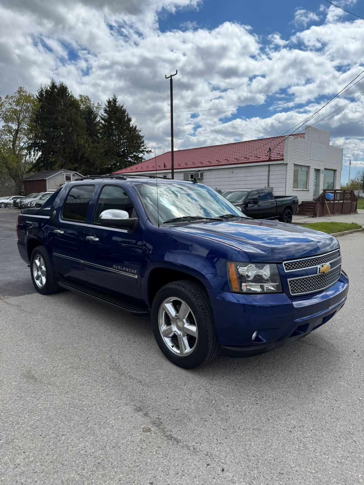 2013 Chevrolet Avalanche LTZ BLACK DIAMOND EDITION 4X4 CREW CAB BLUE front three-quarter exterior view with chrome accents and alloy wheels in daylight.