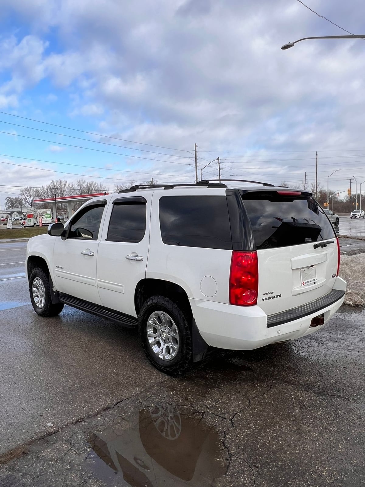 2014 GMC YUKON SLE 4DR White rear three-quarter exterior view with chrome wheels and red taillights in parking lot.