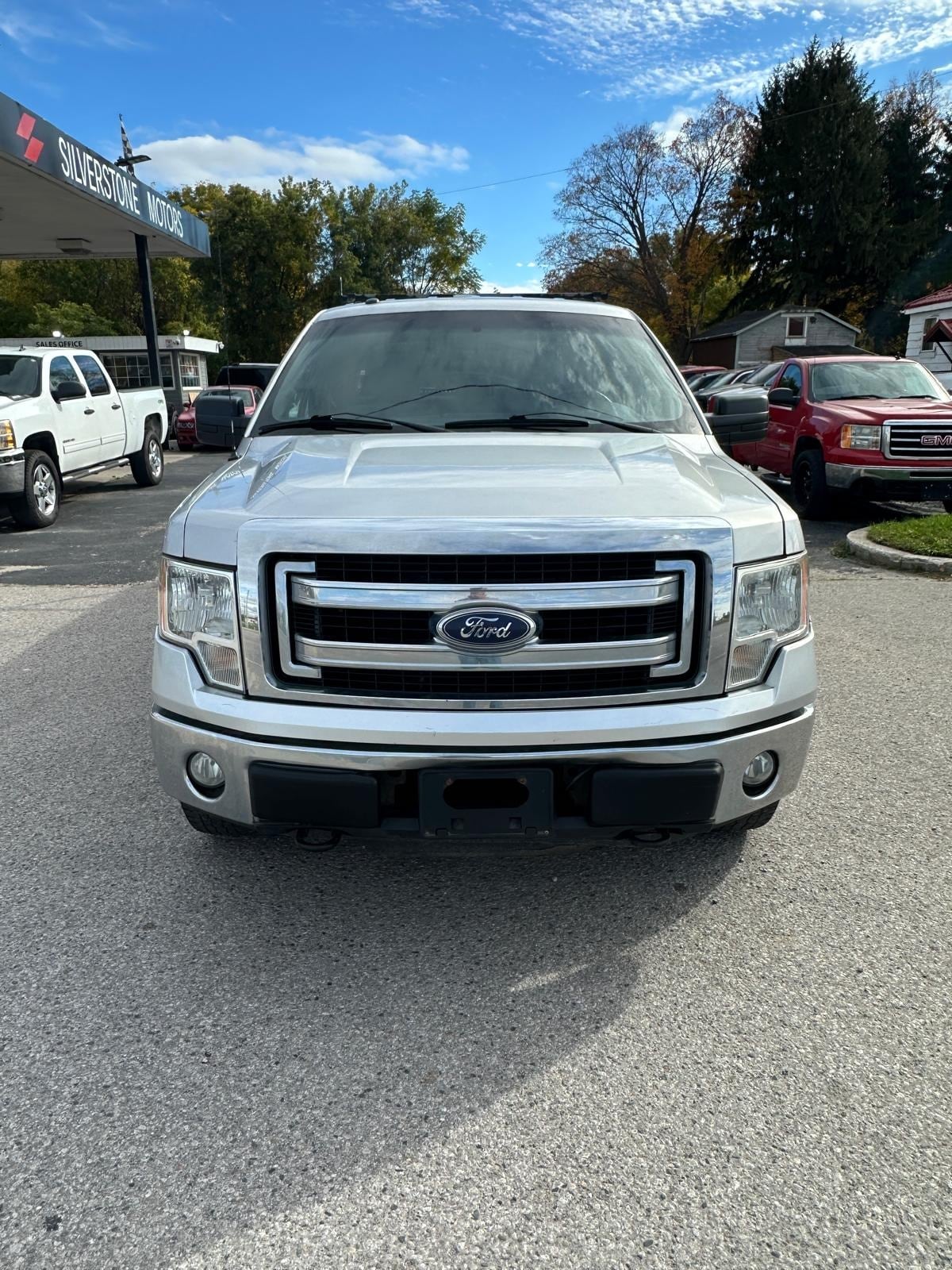 2014 Ford F150 XLT 4WD 5.0L V8 SUPER CAB LONG BOX W/HEAVY DUTY PACKAGE SILVER front exterior view at dealership lot with chrome grille and headlights.