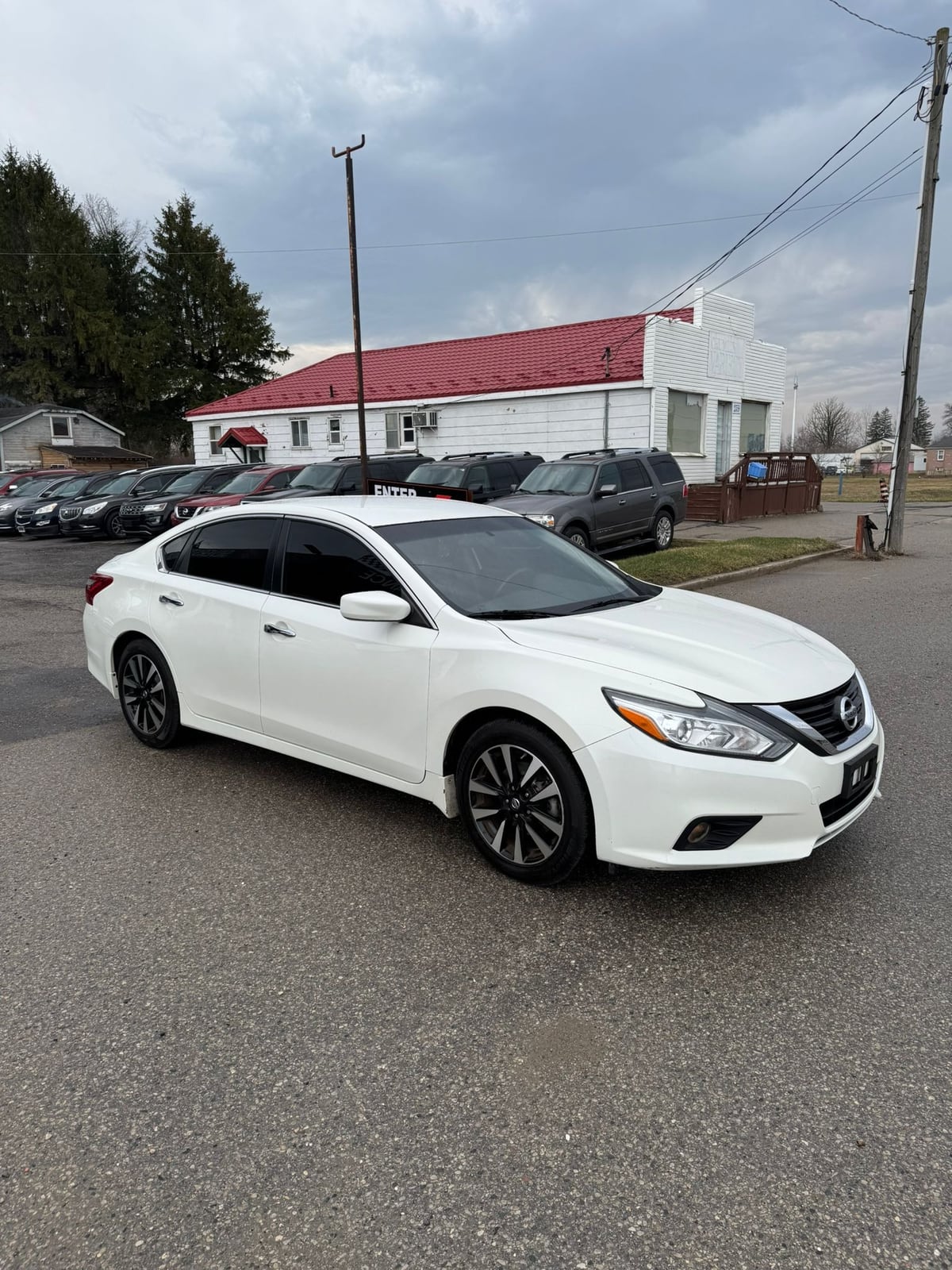 2018 Nissan ALTIMA SV 2.5 4DR White front three-quarter exterior view with alloy wheels in dealership lot.