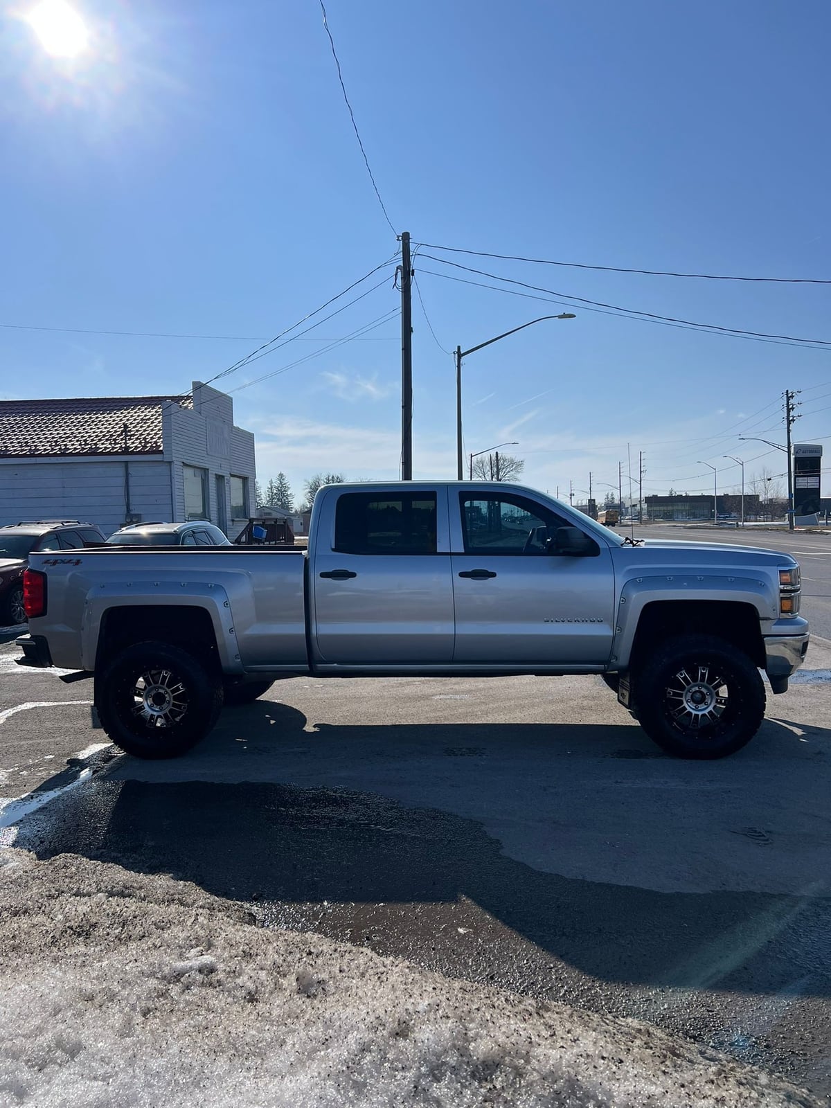 2014 Chevrolet SILVERADO 1500 LT w/1LT 4WD CREWCAB SILVER driver-side exterior view with chrome wheels and open bed door.