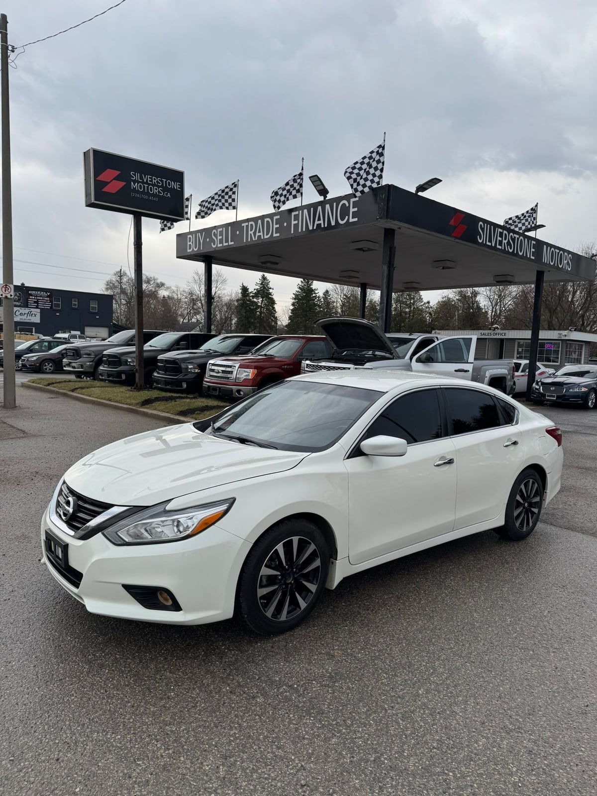 2018 Nissan ALTIMA SV 2.5 4DR White front three-quarter exterior view at dealership with alloy wheels and tinted windows.