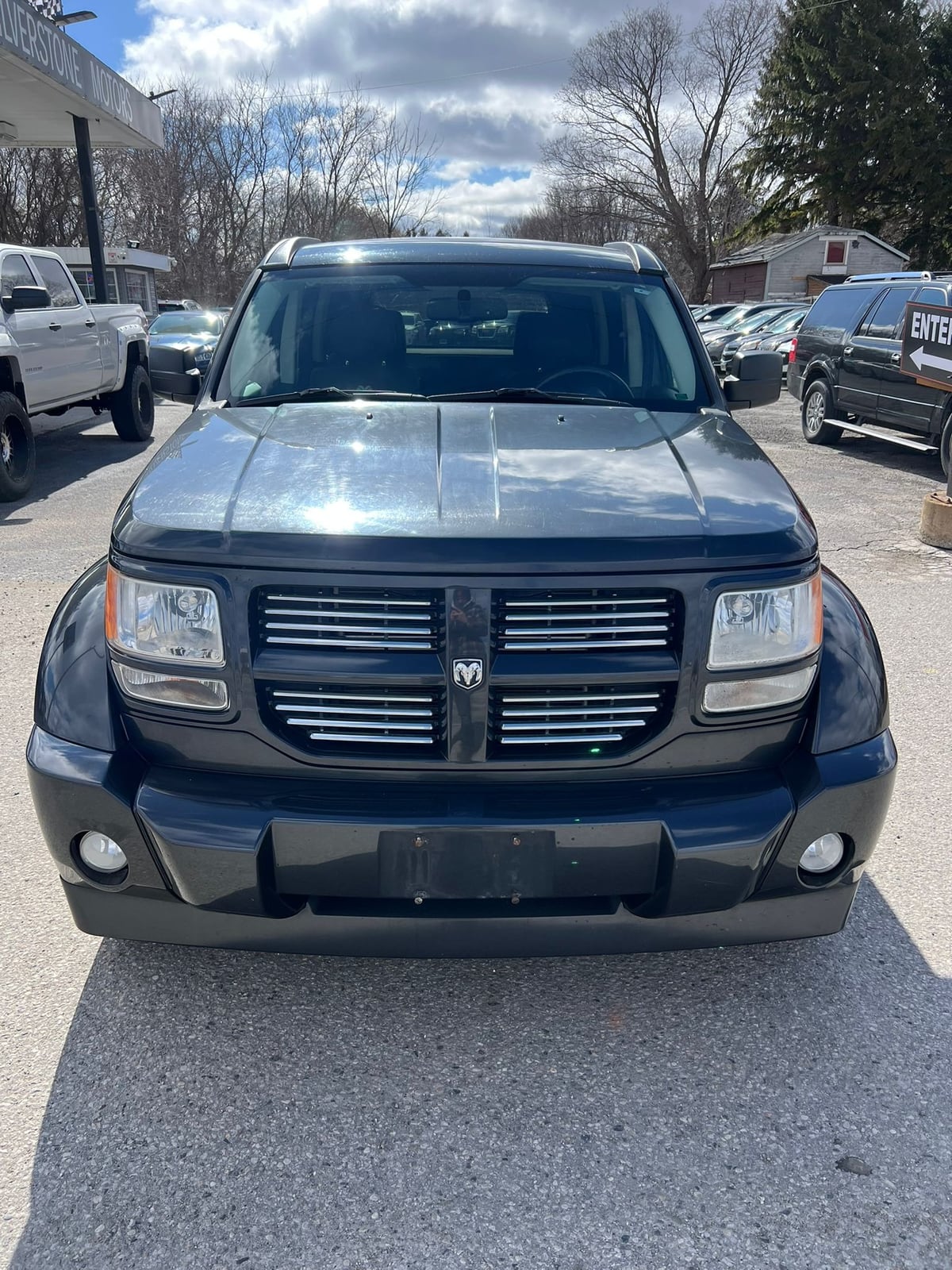 2010 Dodge Nitro SXT 4X4 4DR GREY front exterior view with horizontal grille and fog lights in dealership lot.