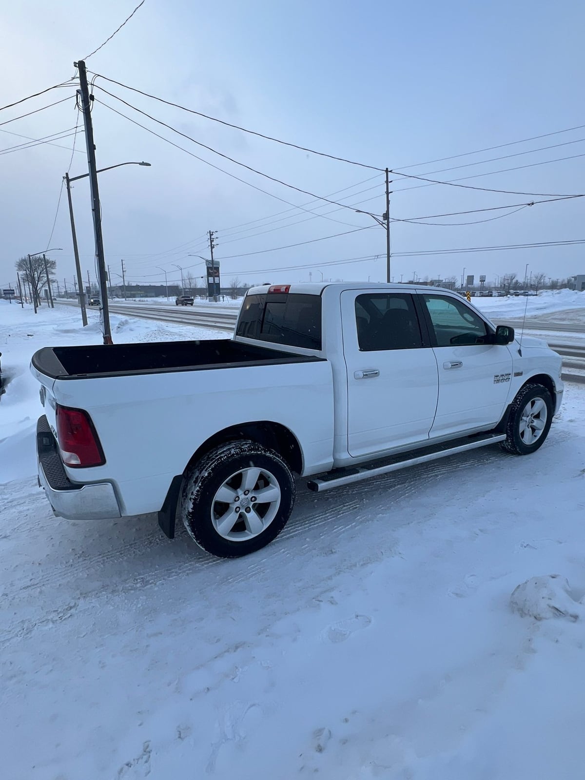 2013 RAM 1500 SLT CREW CAB 4WD SHORT BOX 140.5" White, driver side exterior view on snow-covered ground with alloy wheels visible.