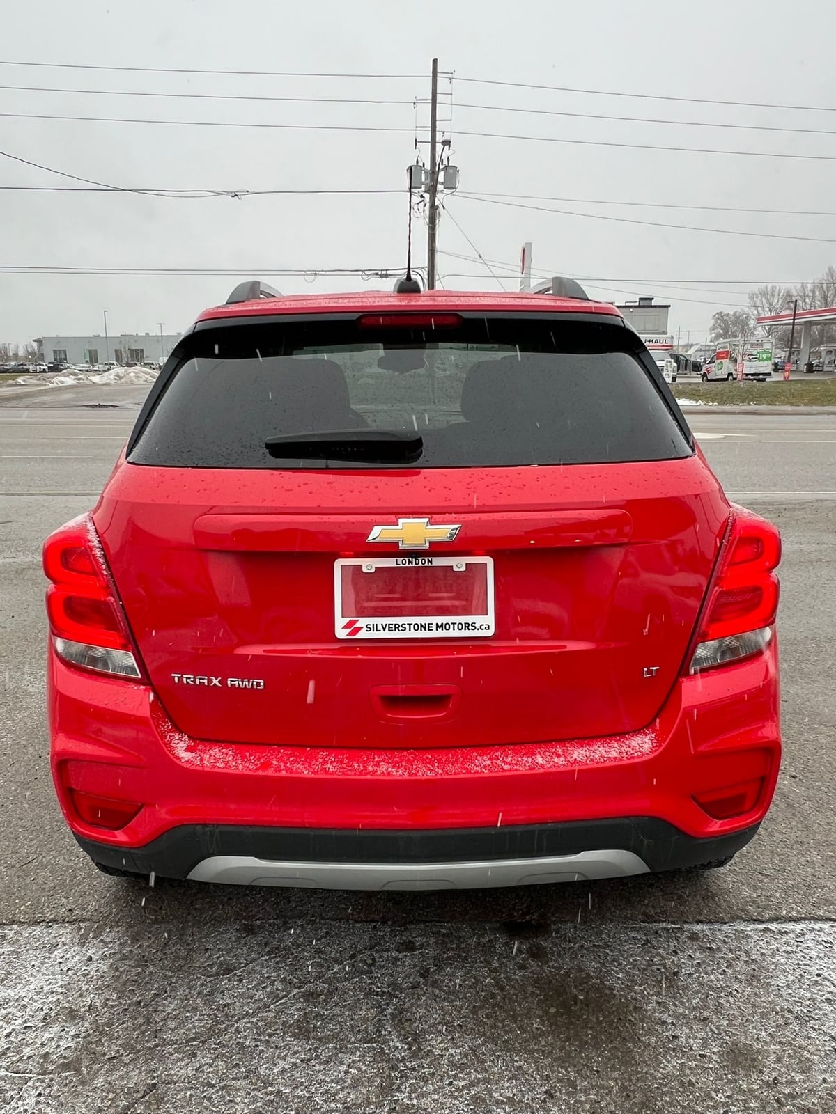 2017 Chevrolet TRAX LT AWD 4DR RED rear exterior view showing badging and taillights in dealership parking lot.