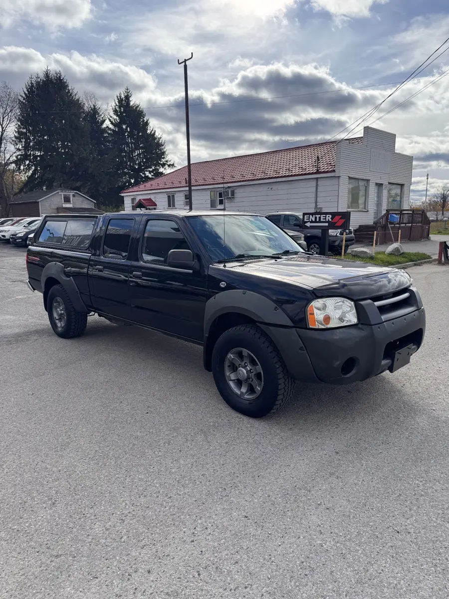 2003 Nissan Frontier XE 3.3 V6 4X4 Crew Cab Standard Box Black, front three-quarter exterior view with tonneau cover and alloy wheels.