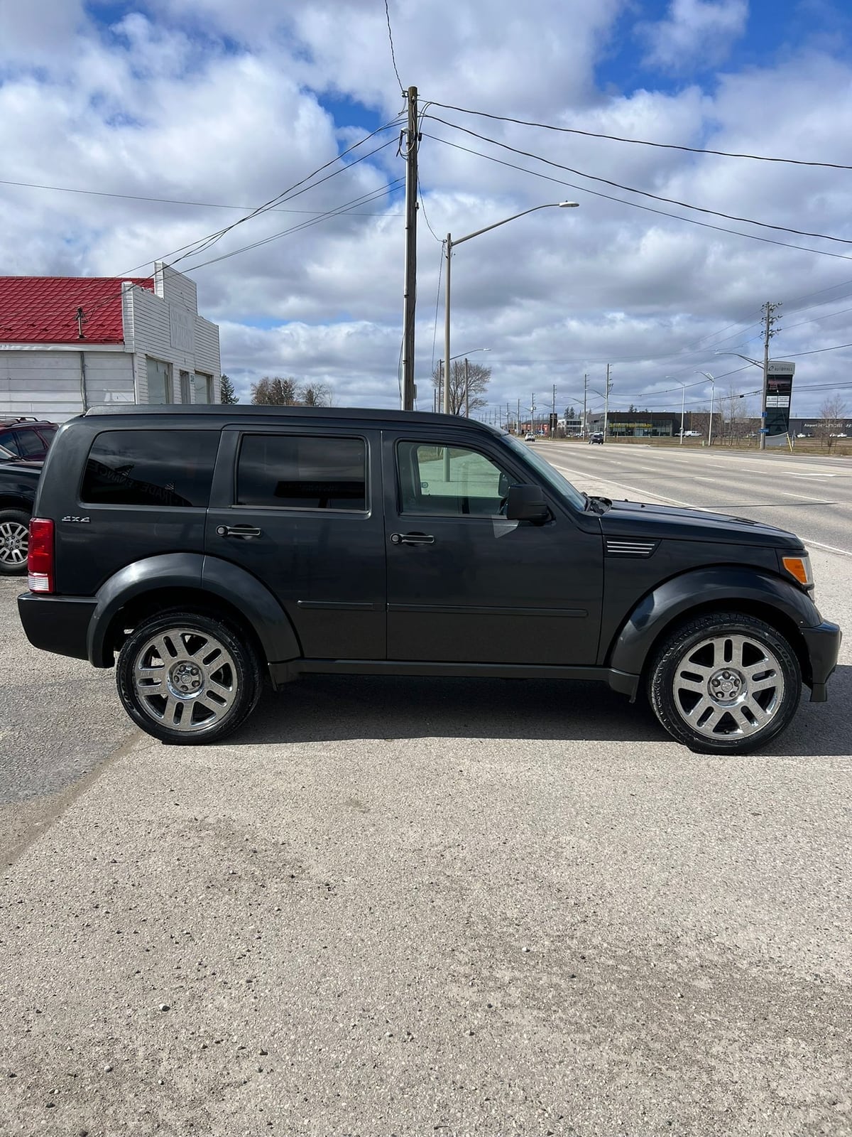 2010 Dodge Nitro SXT 4X4 4DR GREY driver side exterior view with silver alloy wheels and 4X4 badging visible.
