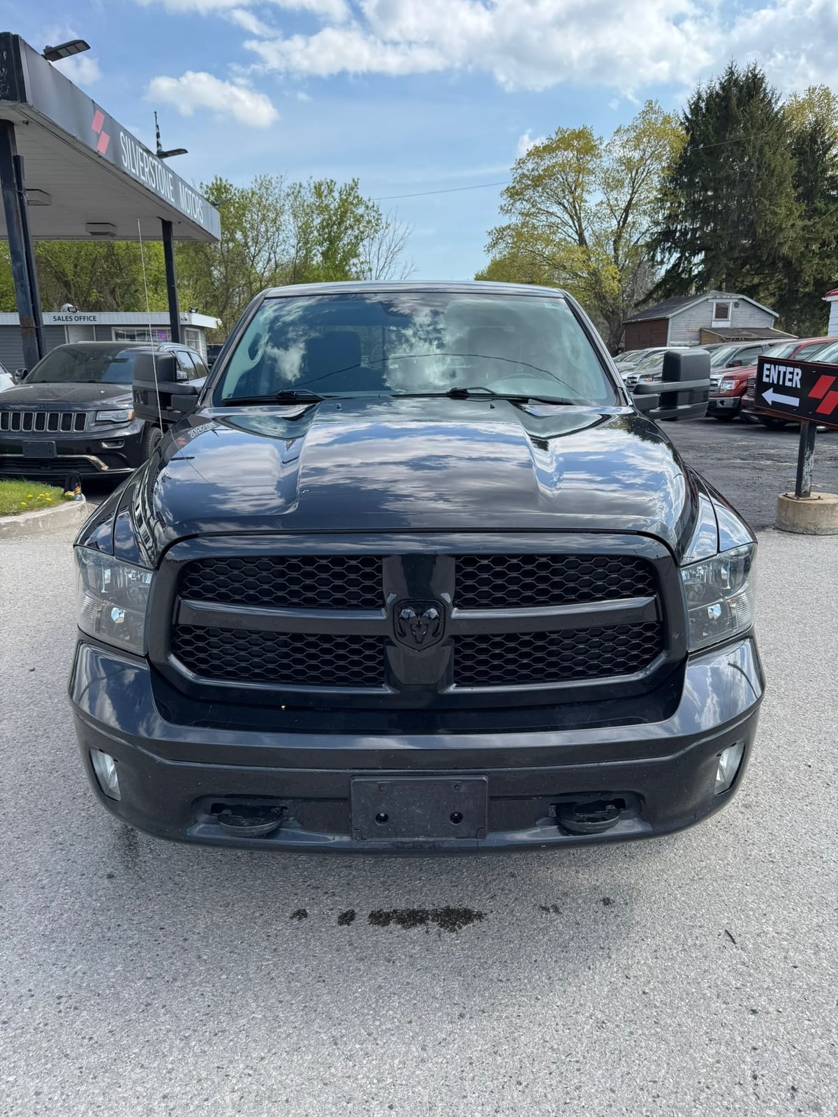 2018 RAM 1500 BIGHORN 4X4 CREW CAB STANDARD BED BLACK front exterior view at dealership lot with prominent grille and headlights.