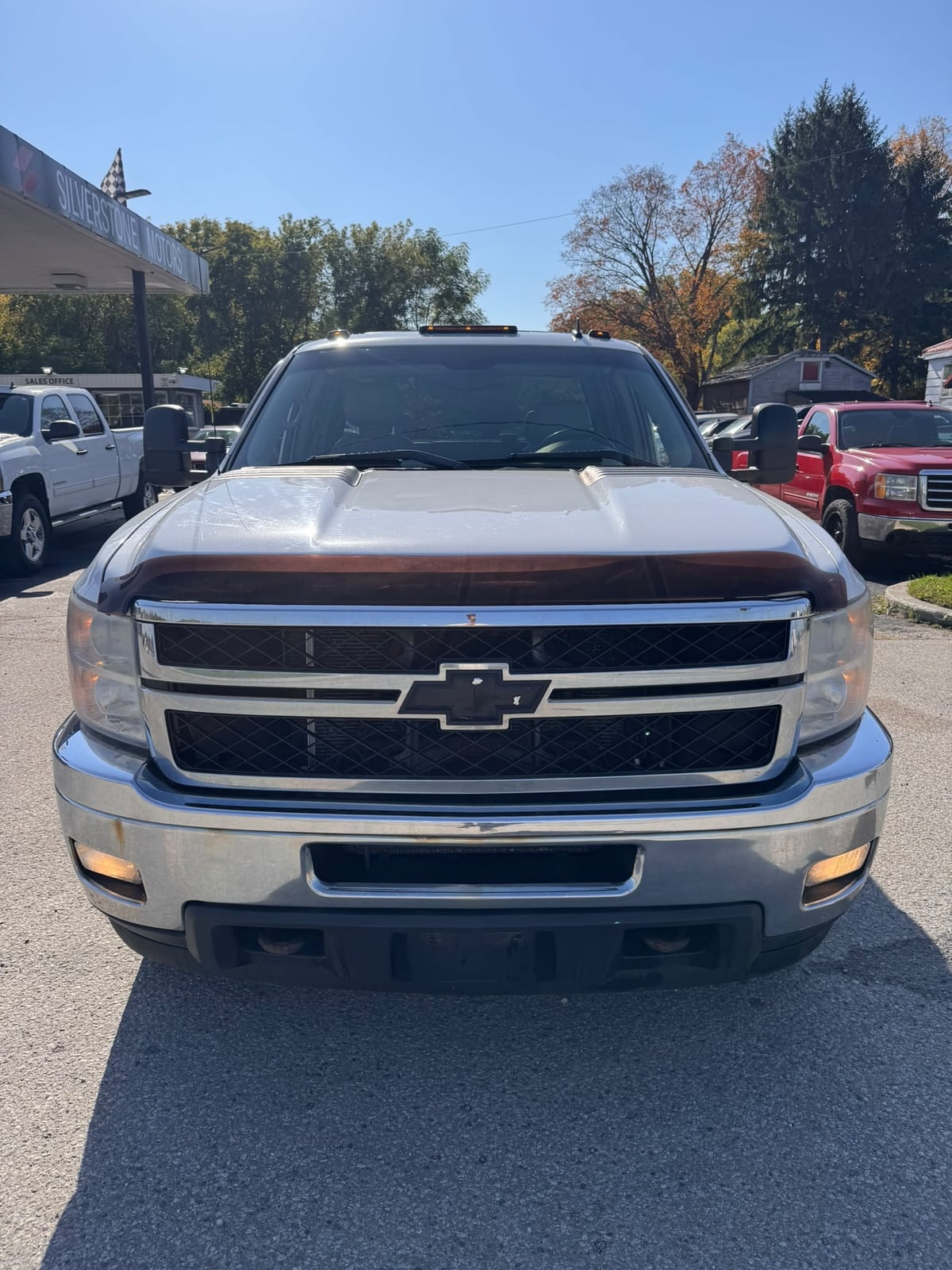 2011 Chevrolet SILVERADO 2500HD LTZ 4WD EXTENDED CAB REG BOX White front exterior view showing chrome grille and bumper in dealership lot.