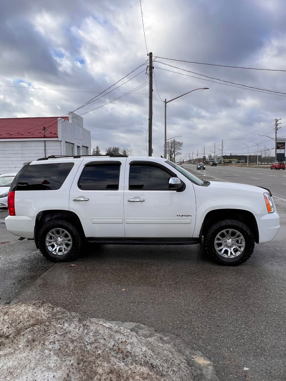 2014 GMC YUKON SLE 4DR White driver side exterior view with chrome alloy wheels and clear skies.