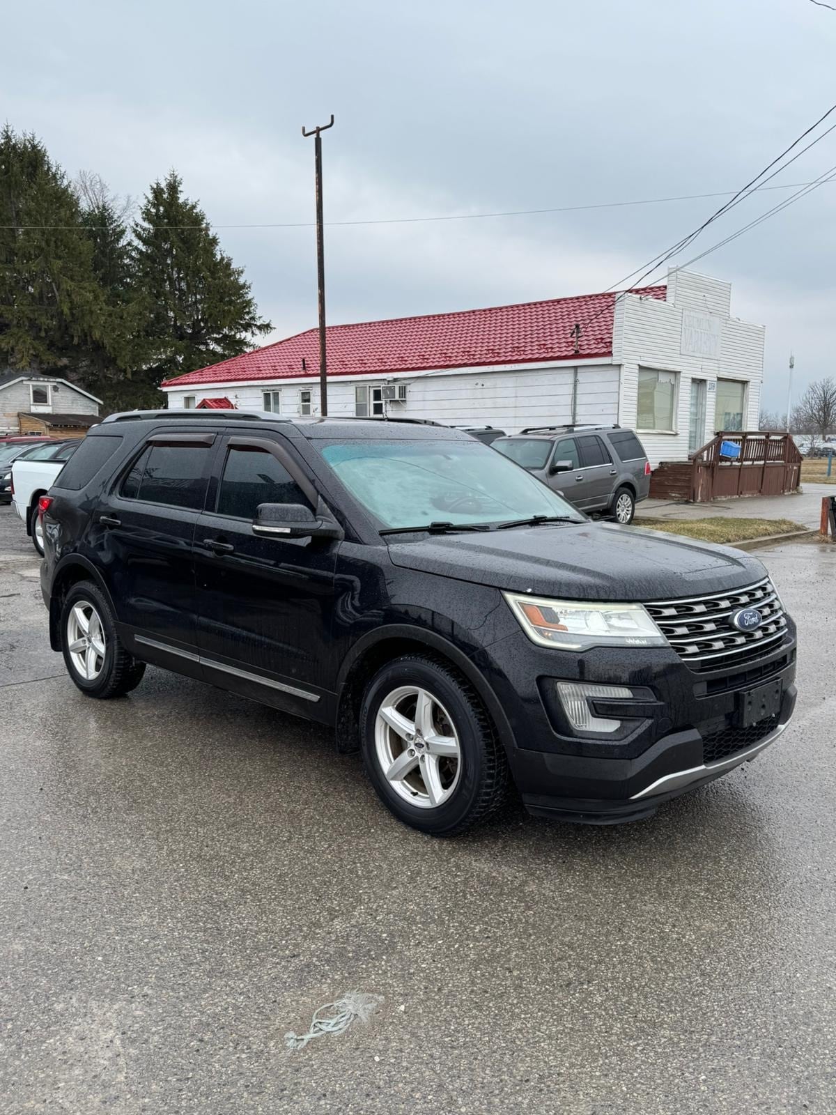 2016 Ford Explorer XLT 4WD 4DR BLACK front three-quarter exterior view with alloy wheels parked in dealership lot.