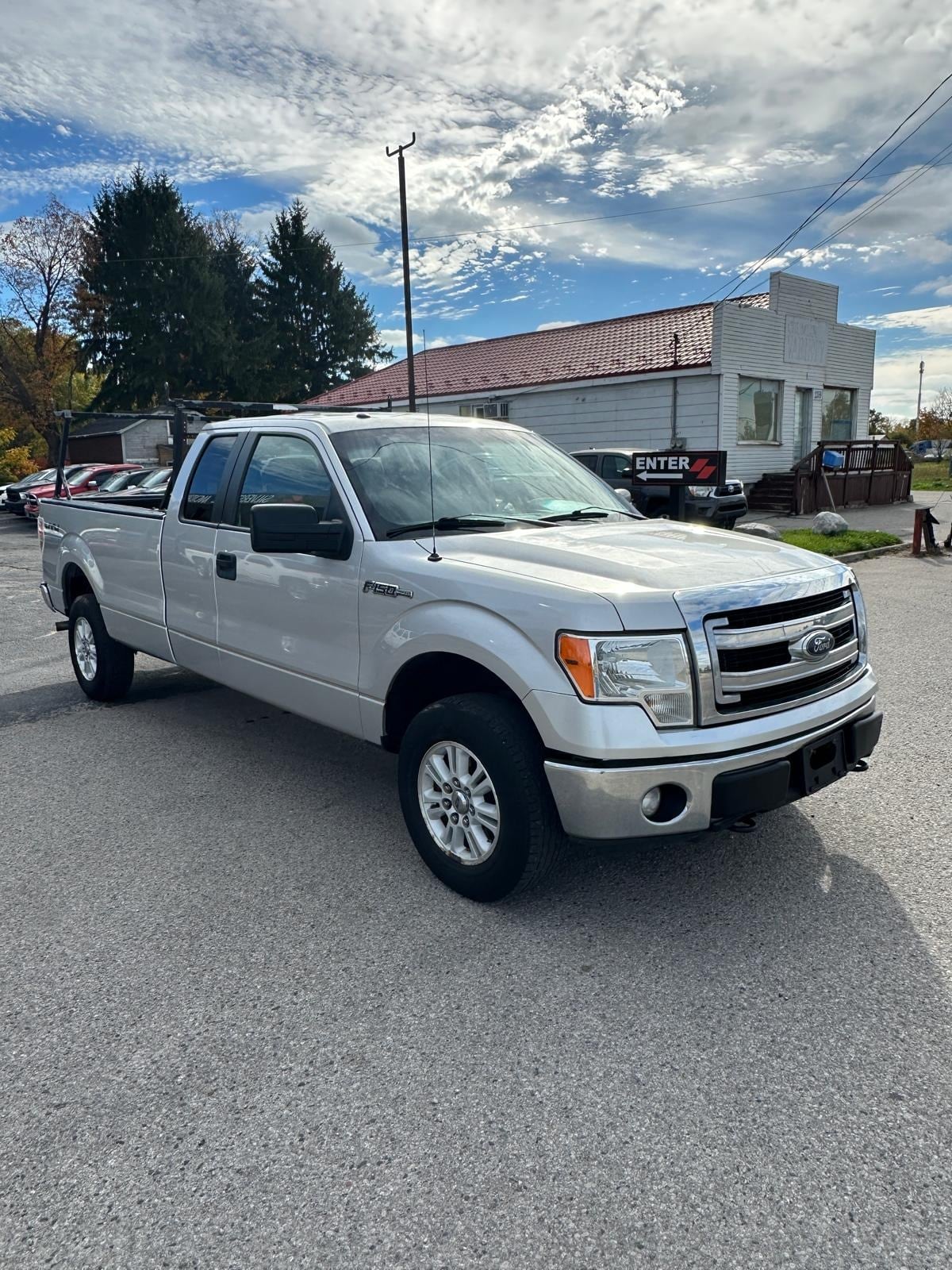 2014 Ford F150 XLT 4WD 5.0L V8 SUPER CAB LONG BOX W/HEAVY DUTY PACKAGE SILVER front three-quarter exterior view with chrome accents and alloy wheels in dealer lot.