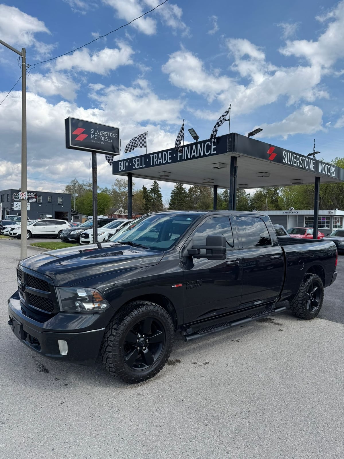 2018 RAM 1500 BIGHORN 4X4 CREW CAB STANDARD BED BLACK front three-quarter exterior view with black custom wheels at dealership lot.