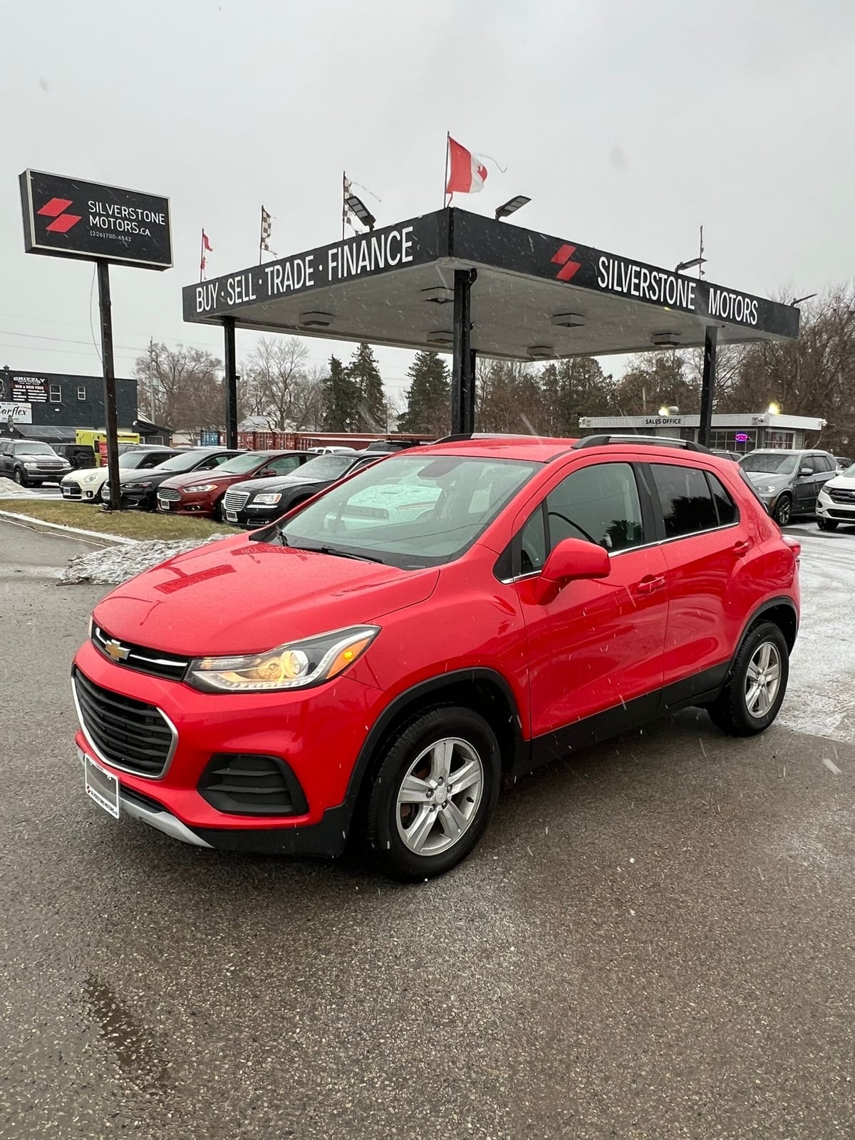 2017 Chevrolet TRAX LT AWD 4DR RED front three-quarter exterior view at dealership lot with silver alloy wheels and LED headlights.