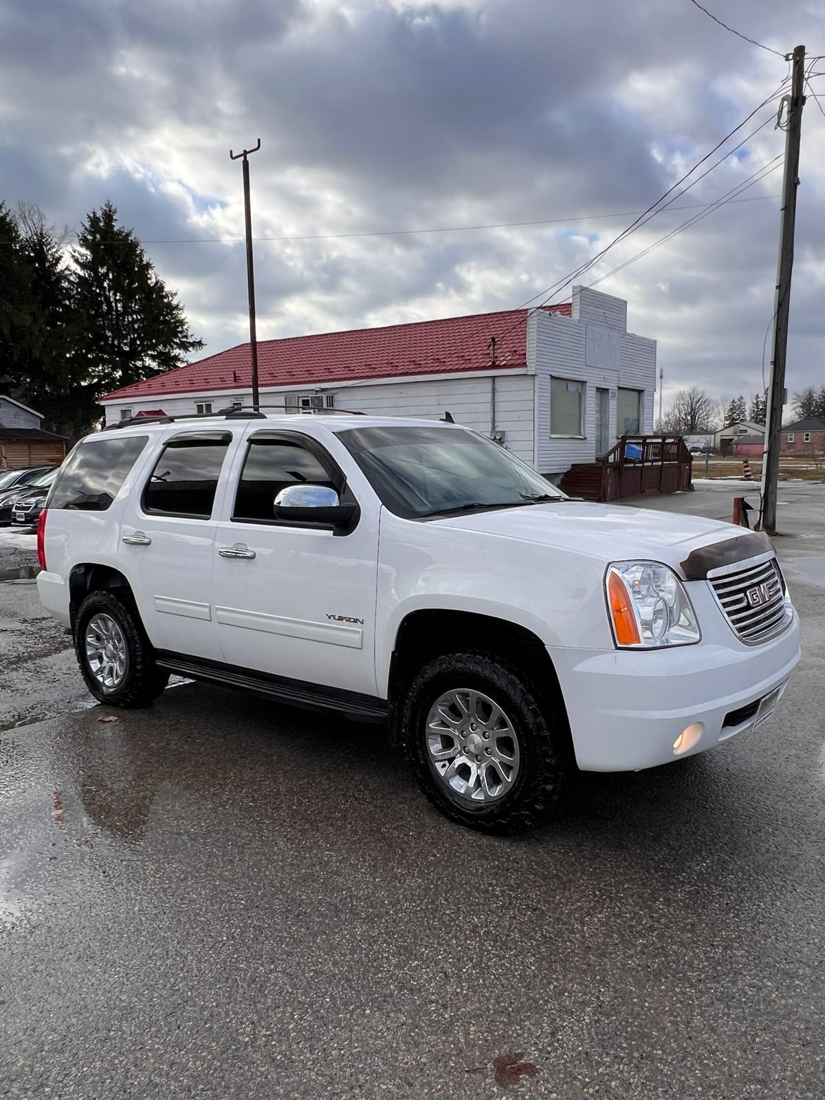 2014 GMC YUKON SLE 4DR White front three-quarter exterior view with chrome wheels parked in lot.