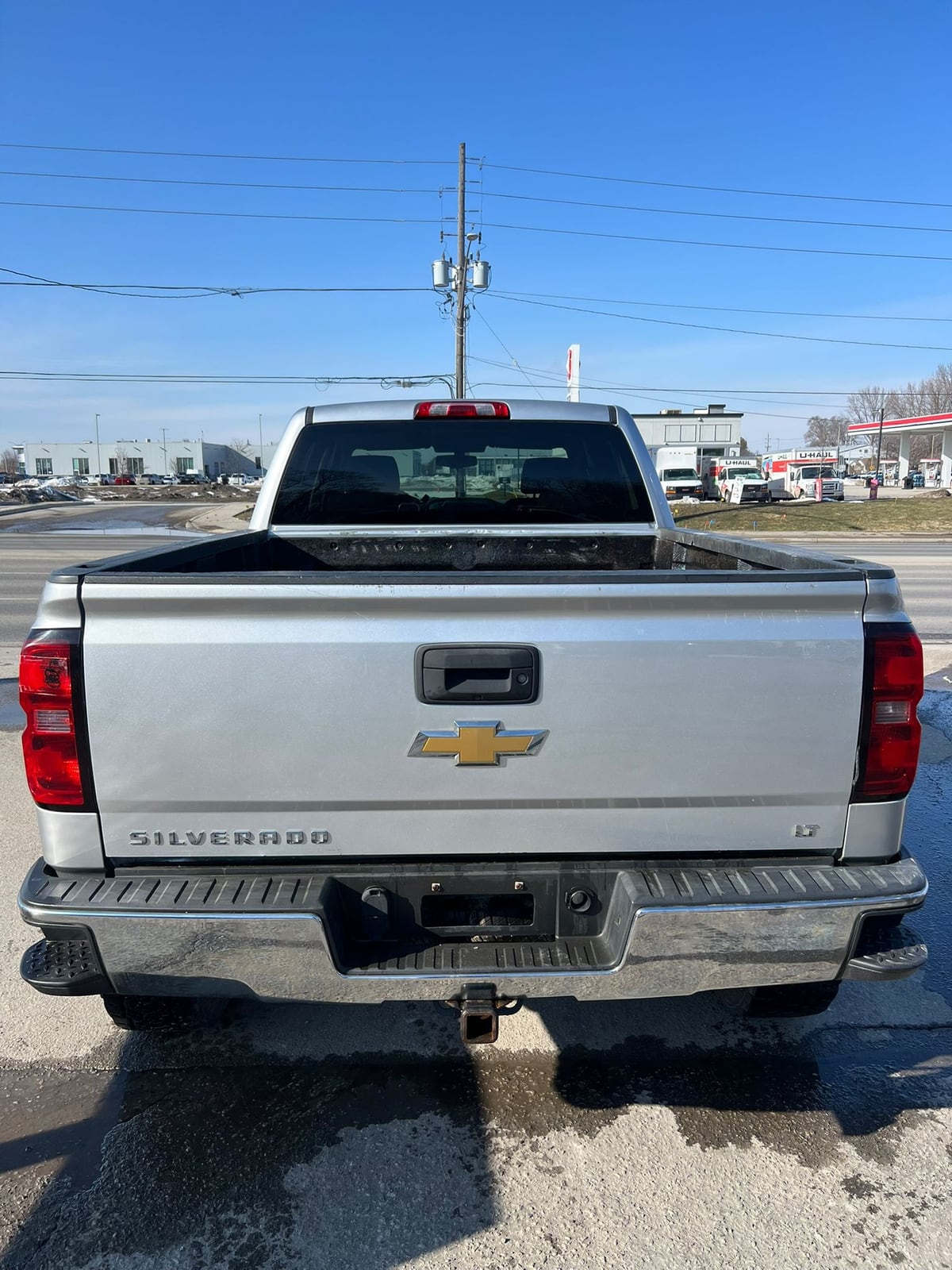 2014 Chevrolet SILVERADO 1500 LT w/1LT 4WD CREWCAB SILVER rear exterior view showing tailgate with Chevrolet badge and red taillights.